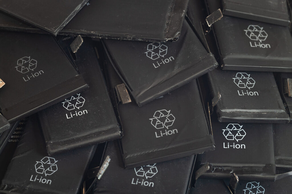 Nahaufnahme alter, gebrauchter Lithium-Polymer-Akkus von Mobiltelefonen, die für das Recycling vorbereitet werden.